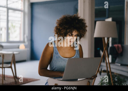 Donna lavoro straordinario nel suo start-up business, utilizzando laptop Foto Stock