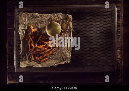 Fatto a mano le patatine fritte con la maionese sulla carta da forno, vassoio da forno, vista aerea Foto Stock