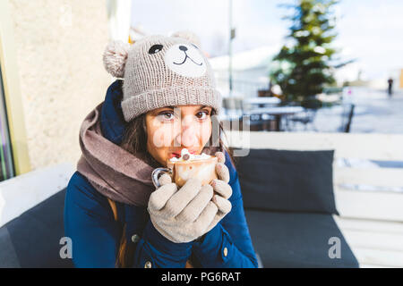 Ritratto di donna di bere un bicchiere di cioccolata calda con panna montata Foto Stock