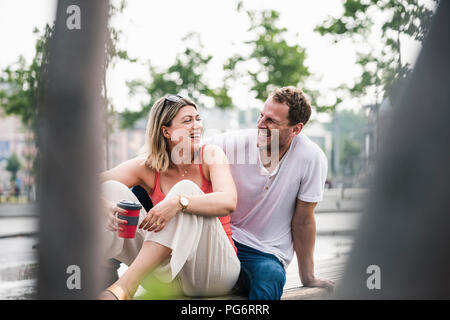 Felice coppia seduta su una panchina Foto Stock