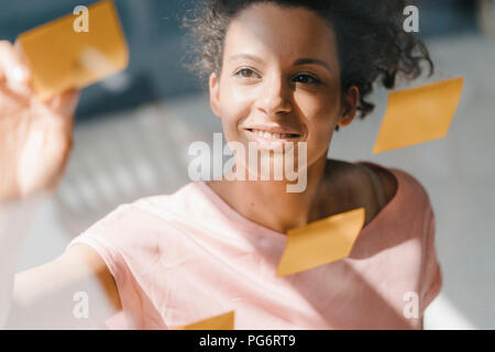 Il brainstorming di donna in office usine note adesive Foto Stock