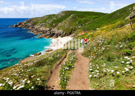 La gente che camminava sul sentiero sopra Porthchapel o Cappella Porth Beach, Cornwall, South West England, Regno Unito Foto Stock