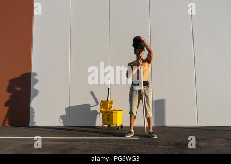 Acrobat giocando con il cucchiaio per la pulitura e la radazza Foto Stock