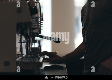 Barista preparazione di caffè in un bar caffetteria, vista parziale Foto Stock