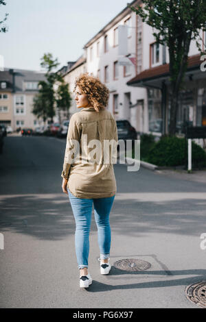 Donna in città a piedi Foto Stock