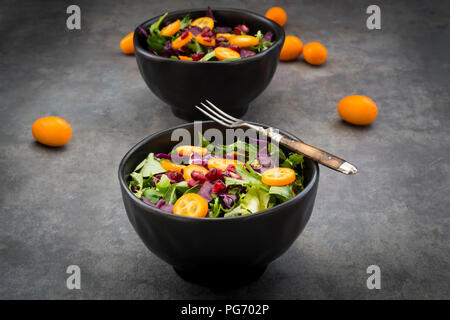 Ciotola di insalata mista con cavolo rosso, kumquat e i semi di melograno Foto Stock
