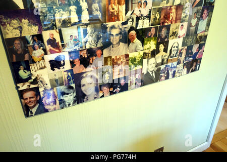 Collage di una raccolta di fotografie di famiglia in una cornice di perspex appeso alla parete Foto Stock
