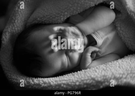 Bambina risveglio al sole nel suo viso. mano sopra il suo occhio in bianco e nero. Foto Stock