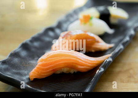 Rotolo di Sushi con salmone e sushi roll con anguilla affumicata, il fuoco selettivo. Close up di sashimi sushi set Foto Stock