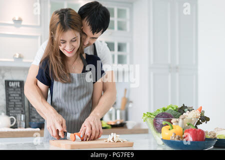 Giovane bella giovane in cucina. Famiglia di due nella preparazione degli alimenti. Giovane rendendo deliziosa insalata. La cottura di hobby il concetto di stile di vita. Foto Stock