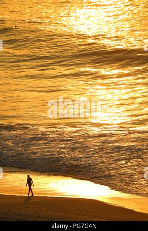 Vista aerea dell'oceano atlantico in luce del sole di mattina riflessione con la sagoma di un uomo a camminare sulla spiaggia di Copacabana e di Rio de Janeiro del Brasile Foto Stock