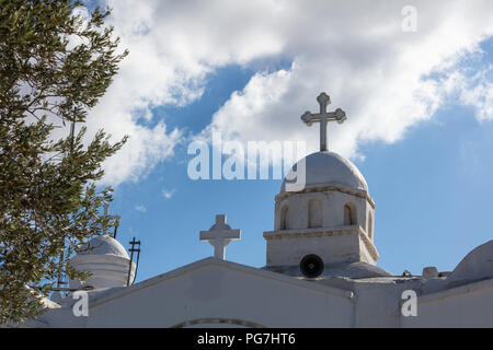 Chiesa con cupola di colore bianco ad Atene in Grecia, su un cielo blu di sfondo e olivo in primo piano. Foto Stock