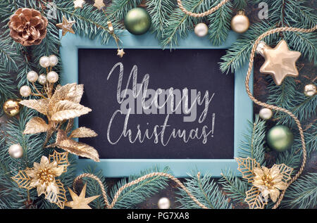 Verde e oro sullo sfondo di Natale. Decorate Abete rami attorno a Chalk board su sfondo scuro. Vista da sopra con il testo 'buon Chtistmas!". Foto Stock