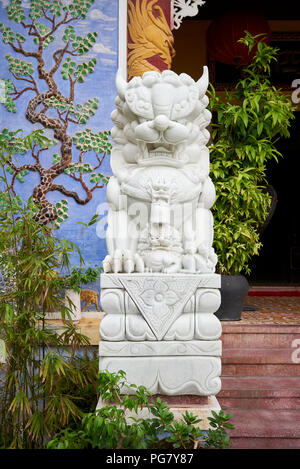 Statua di lion-dog nel giardino della Phap Bao tempio buddista della città di Hoi An, Vietnam centrale. Foto Stock