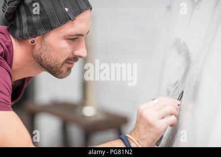 Focalizzato artista disegno su tela Foto Stock