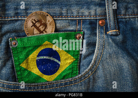 Golden BITCOIN (BTC) cryptocurrency nella tasca dei jeans con la bandiera del Brasile Foto Stock