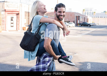 Felice giovane ragazza portante sovrapponibile Foto Stock