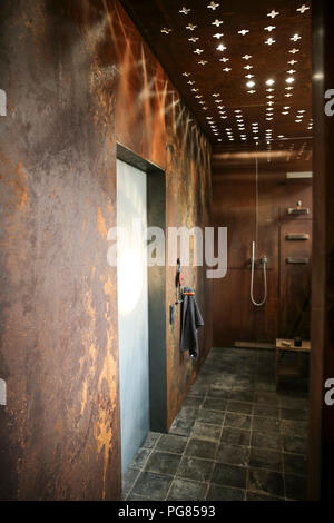 Bagno moderno con acciaio corten rivestimento pareti e soffitto effetti di luce Foto Stock