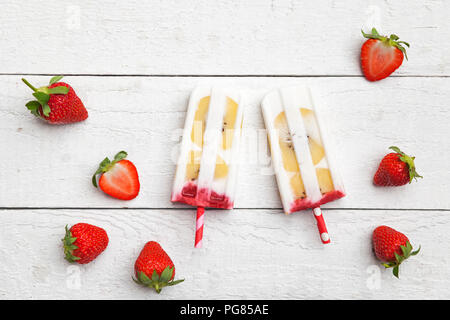 In casa di cocco fragola ghiaccioli con kiwi fette di frutta Foto Stock