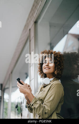 Donna della città utilizza lo smartphone Foto Stock