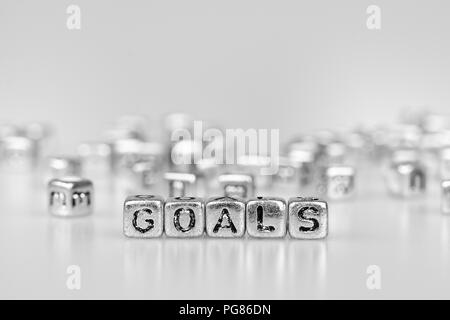 Obiettivi parola scritta sul cubo di argento con il bianco e nero bokeh cube parola sullo sfondo del blocco Foto Stock