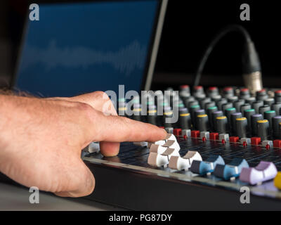 Uomo suono di regolazione sul mixer audio nella stazione radio Foto Stock