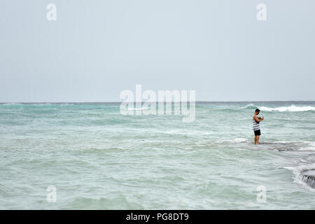 Honolulu, Stati Uniti d'America. 23 Ago, 2018. Un uomo prende le immagini sul Seawall presso la spiaggia di Waikiki a Honolulu delle Hawaii, Stati Uniti, e il agosto 23, 2018. Uragano Lane, predetta come la più grande minaccia meteo alle Hawaii in decenni, spostato pericolosamente vicino alla stato di Aloha giovedì mattina, innescando heavy rain, frane e inondazioni. Credito: Sun Ruibo/Xinhua/Alamy Live News Foto Stock