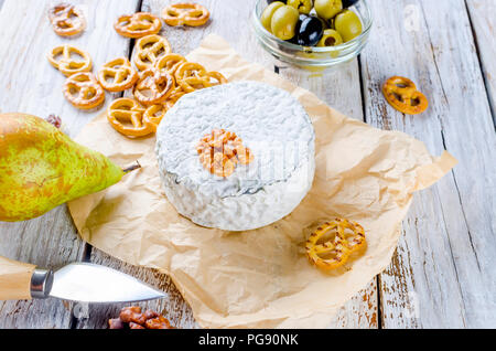 Testa di cagliata di formaggio blu e olive. miele e pera, pretzel su bianco vecchio tavolo in legno, vista dall'alto Foto Stock