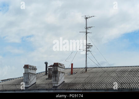 Camini e antenna sul tetto di una casa appartamento contro il cielo nuvoloso. Komsomolsk-su-Amure, Russia Foto Stock