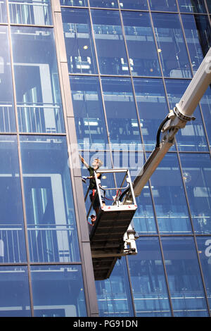 Copenaghen, Danimarca - Agosto 17, 2018: window cleaners lavorando su di un moderno ed alto edificio di vetro Foto Stock