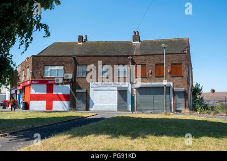 San Giorgio a bandiera dipinta sulla parete della scatola negozi immobiliari, Roma Anagnina, West Midlands. Foto Stock