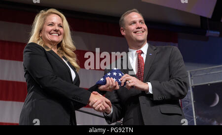 SpaceX Presidente e Amministratore Delegato di funzionamento Gwynne Shotwell riceve una bandiera americana da amministratore della NASA Jim Bridenstine durante un evento della NASA annuncia gli astronauti assegnato all equipaggio il primo test di volo e le missioni del Boeing CST-100 Starliner e equipaggio SpaceX Dragon, Venerdì, 3 Agosto, 2018 alla NASA Johnson Space Center a Houston, Texas. La bandiera è di essere volato per la Stazione Spaziale Internazionale a bordo della SpaceX Demo-2 equipaggio prova di volo e recuperati in seguito durante l'equipaggio SpaceX Dragon prima missione alla stazione. Foto Stock