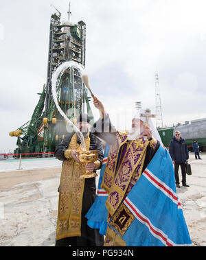 Un sacerdote ortodosso benedice i membri dei media presso il cosmodromo di Baikonur launch pad, Martedì, Marzo 20, 2018 di Baikonur in Kazakhstan. Expedition 55 Soyuz Commander Oleg Artemyev di Roscosmos, Ricky Arnold e Drew Feustel della NASA sono in programma di lancio per la Stazione Spaziale Internazionale a bordo della Soyuz MS-08 navicella spaziale su Mercoledì, Marzo 21. Foto Stock