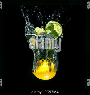 Cocktail Mojito in vetro immaginario con spruzzi di acqua da limone su sfondo nero Foto Stock