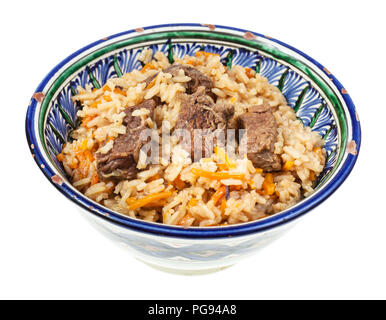 Al di sopra di vista del preparato pilaf (Asia centrale piatto di riso con carne e verdure) in ceramica tradizionale recipiente isolato su sfondo bianco Foto Stock