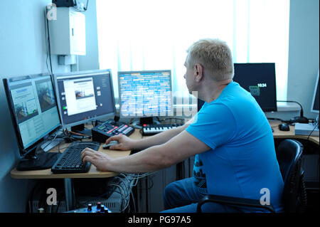Ingegnere di video editing di video registrazioni seduti nella parte anteriore del monitor per le notizie di agenzia studio. Agosto 10, 2018. A Kiev, Ucraina Foto Stock