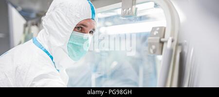 I tecnici al lavoro in sterile sigillato unità isolatore in un laboratorio che produce tessuti umani per l'impianto. Tali tessuti comprendono osso e trapianti di pelle. Foto Stock