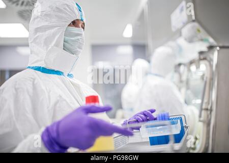 Il tecnico il trasporto di attrezzature in un laboratorio che produce tessuti umani per l'impianto. Tali tessuti comprendono osso e trapianti di pelle. Foto Stock