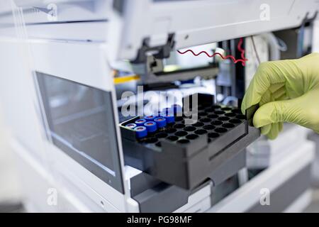 Campioni essendo collocato in un concentratore. Questo dispositivo si concentra o evapora di campioni di materiale biologico per prepararli per l'analisi. Foto Stock
