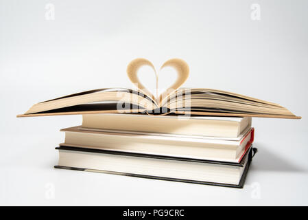 Close up del libro aperto con cuore sagomato da due pagine, isolati su sfondo bianco. Foto Stock