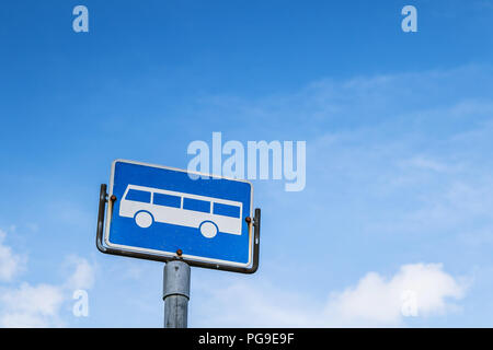 Fermata bus segno contro il cielo blu. Foto Stock