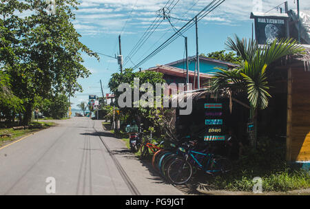 Strada costeggiata con noleggio biciclette negozi e caffetterie in una popolare destinazione turistica di Puerto Viejo, sul lato caraibico del Costa Rica Foto Stock