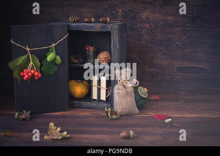 Tintura di piccole bottiglie, ghiande, dadi, foglie, zucche, una pila di libri, autunno, halloween proveniente cartolina concetto, tonica Foto Stock