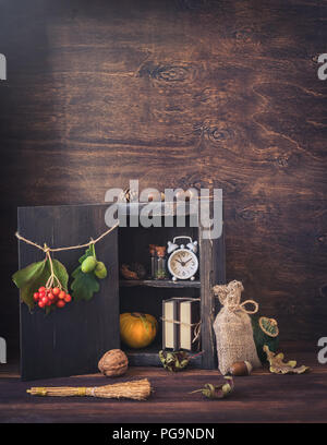 Tintura di piccole bottiglie, ghiande, dadi, foglie, zucche, una pila di libri, autunno, halloween proveniente cartolina concetto, tonica Foto Stock