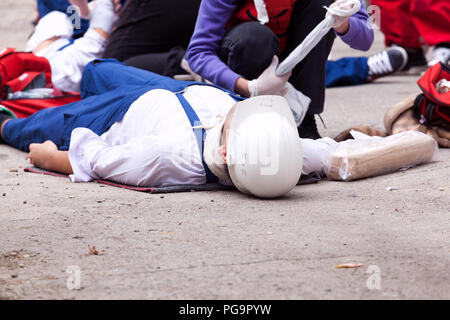 I paramedici aiutando un lavoratore dopo la caduta in un cantiere. Formazione di primo soccorso. Foto Stock