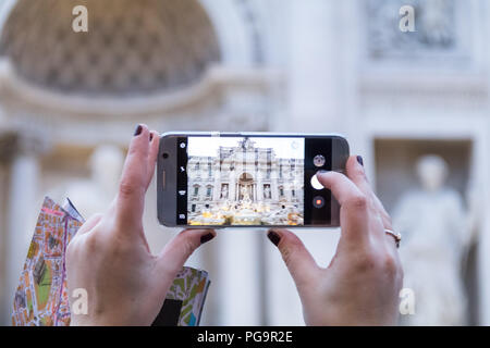 La fontana di Trevi visibili nel telefono cellulare schermo .tenuta in mano lo smartphone tenendo la foto in Roma. Foto Stock
