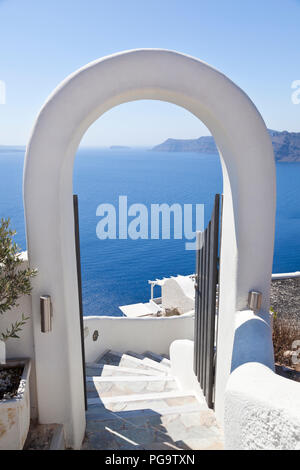 Un arco di Oia con vista verso le altre isole del bordo del cratere di Santorini. Foto Stock