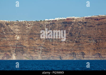 Le pareti del cratere della caldera di Santorini, Grecia. Alcuni edifici a destra sul bordo. Foto Stock