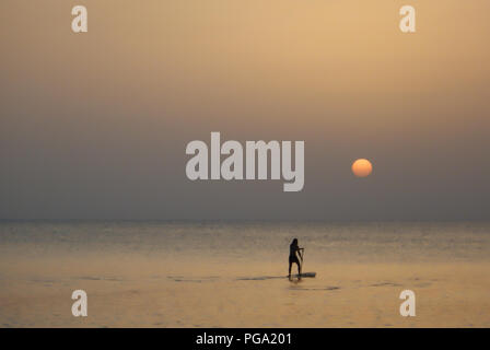 Imbarco a pale al tramonto nel mare dei Caraibi off Seven Mile Beach nelle isole Cayman. Foto Stock