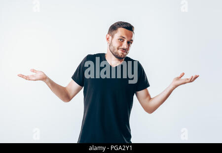 Confuso giovane uomo ha un dubbio gesti con le mani Foto Stock